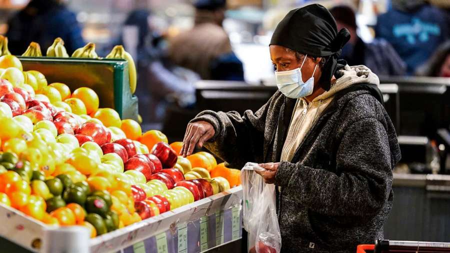 Woman in mask choosing tomatoes at indoor market — Buy Wallpaper