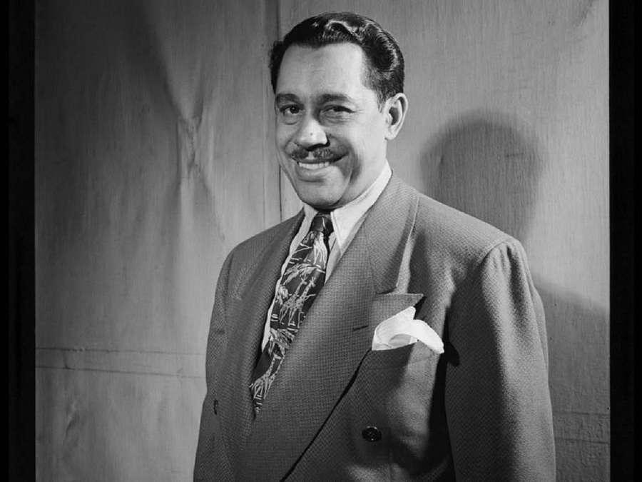 Ein lächelnder Mann in Anzug und gemusterter Krawatte posiert für ein klassisches Schwarz-Weiß-Porträt. — Cab Calloway Bilder