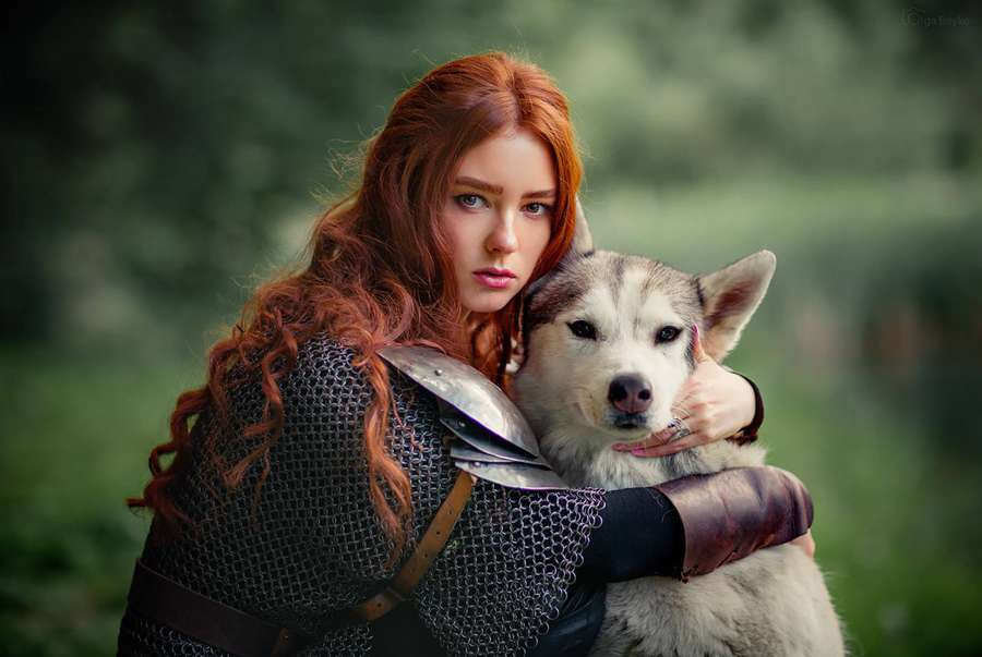 Guerreira ruiva de cota de malha abraça um cão husky em uma floresta. — Cachorro e menina Papéis de Parede