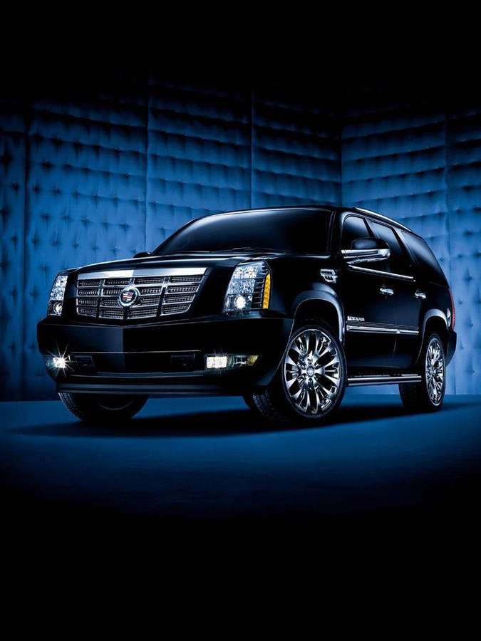 Sort Cadillac Escalade SUV i et blåbelyst studie med tuftede fløjlsvægge. — Cadillac iPhone Wallpapers