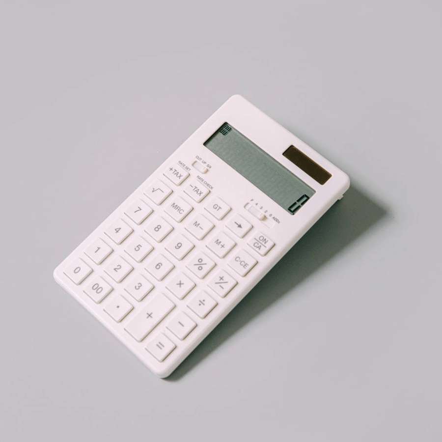 Calculadora branca em superfície cinza projetando sombra suave — Calculadora Papéis de Parede