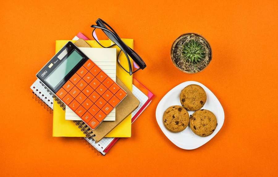Calculator notebooks glasses cookies and cactus on orange background — Calculator Wallpaper