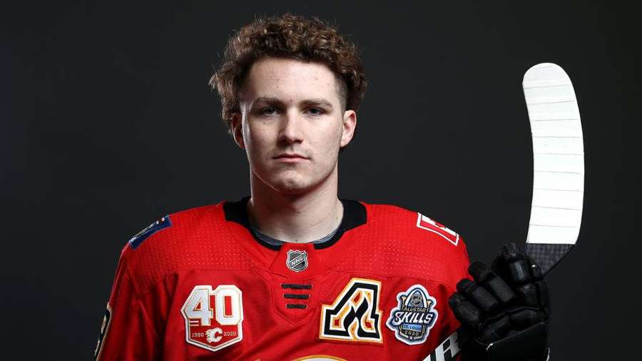 Hockeyspieler in rotem Trikot hält Schläger im Studio — Calgary Flames Bilder