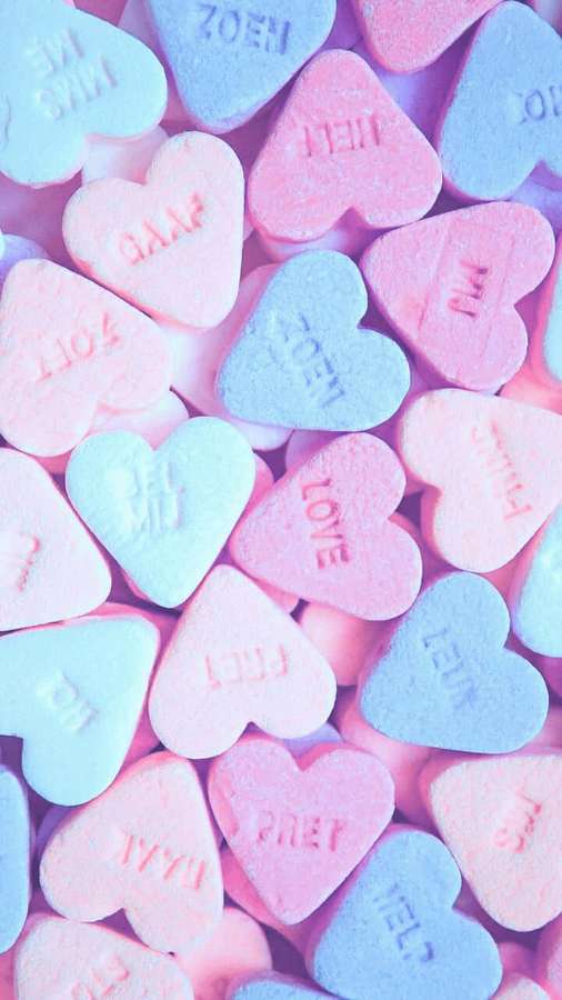 Pastel pink and blue heart candies with words like love and sweet embossed on them. — Candy Aesthetic Background