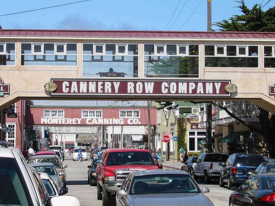 Cannery Row street with parked cars and historic buildings under a blue sky. — Cannery Row Wallpaper
