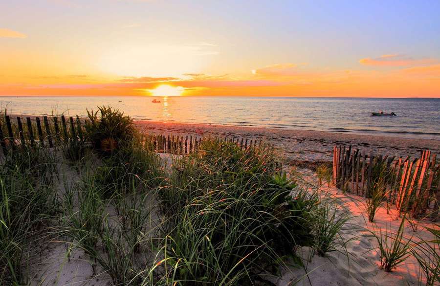 Sunset over ocean with dune grass and wooden fence on beach — Cape Cod Wallpaper