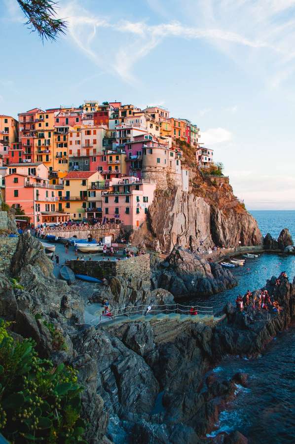 Pueblo costero colorido en acantilado con personas disfrutando de vistas al mar al atardecer. — Capri Fondos de pantalla