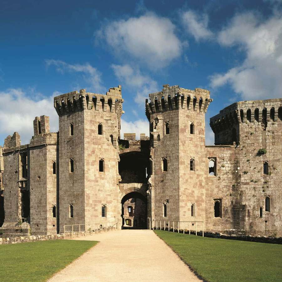Ancient stone castle with towers and arched entrance under a blue sky with clouds. — Cardiff Castle Wallpaper