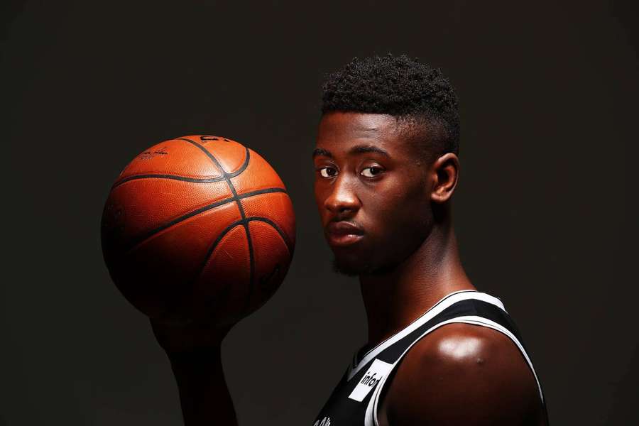 Junger Basketballspieler hält einen Ball in einer Studioaufnahme. — Caris levert Wallpaper