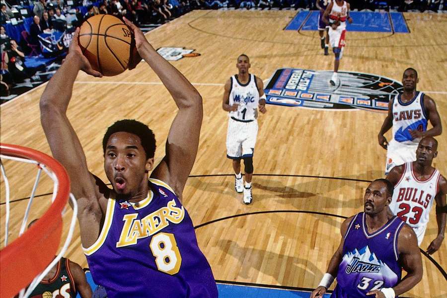Basketballspieler in lila Lakers-Trikot dunkt den Ball während eines Spiels. — Carl Malone Wallpaper