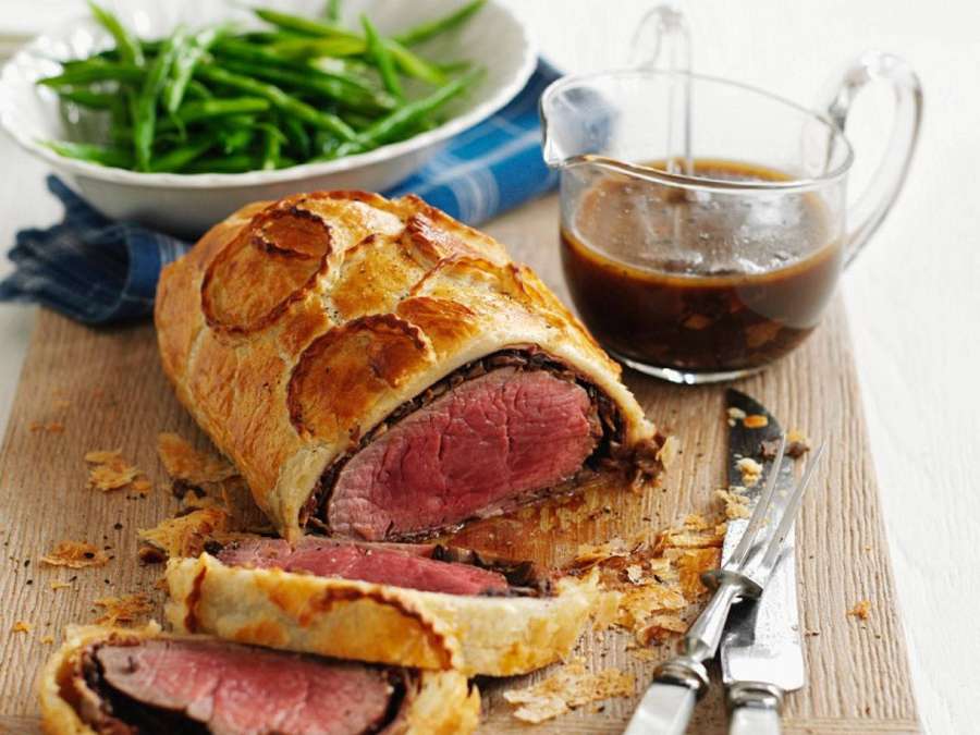 Beef wellington rebanado con judías verdes y salsa sobre una tabla de madera. — Carne Fondos de pantalla