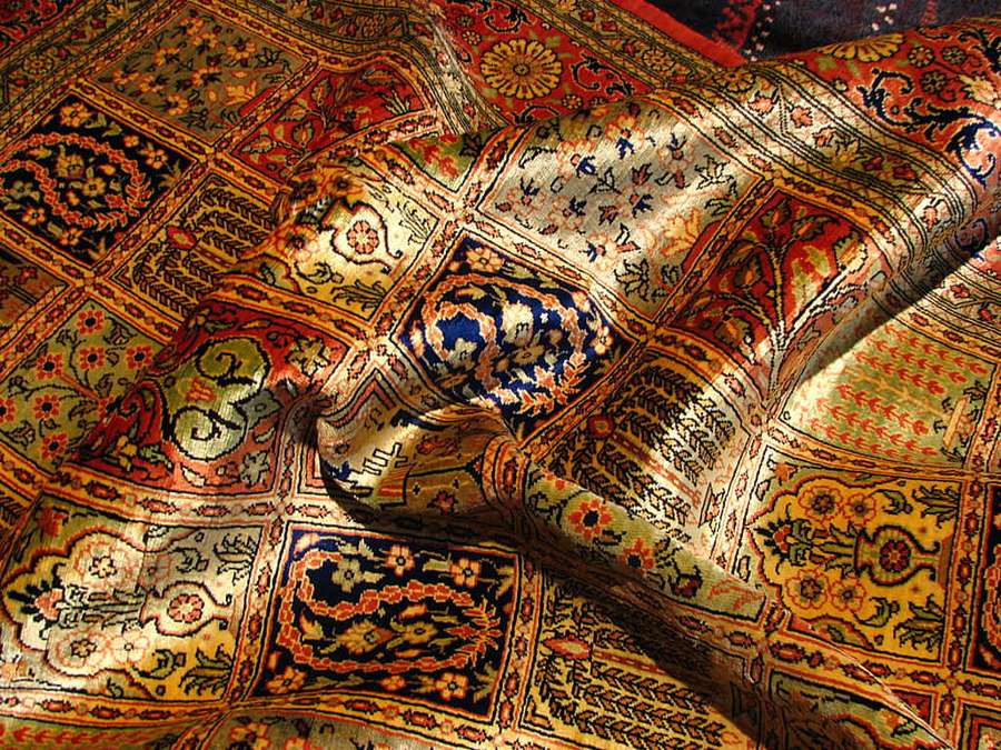 Close-up of a luxurious Persian rug with intricate patterns and warm colors. — Carpet Background