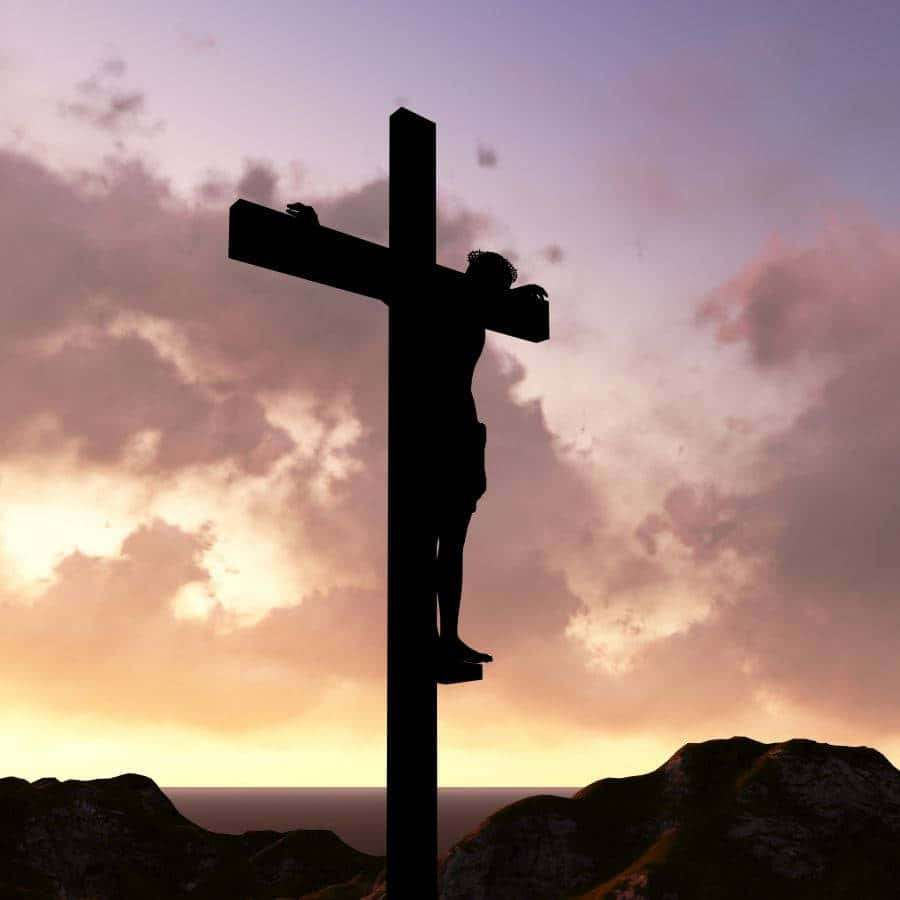 Silhouette of Jesus on a cross at sunset over mountains — Catholic Aesthetic Wallpaper
