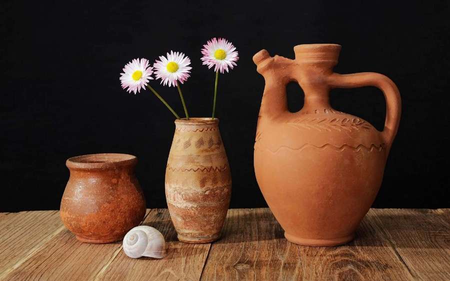 Still life of terracotta pots daisies and seashell on wooden surface. — Ceramics Wallpaper