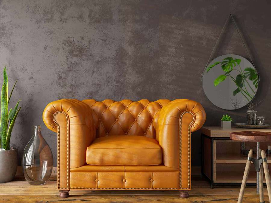 Amber leather Chesterfield sofa in a rustic industrial living room with plants and wooden furniture. — Chair Wallpaper