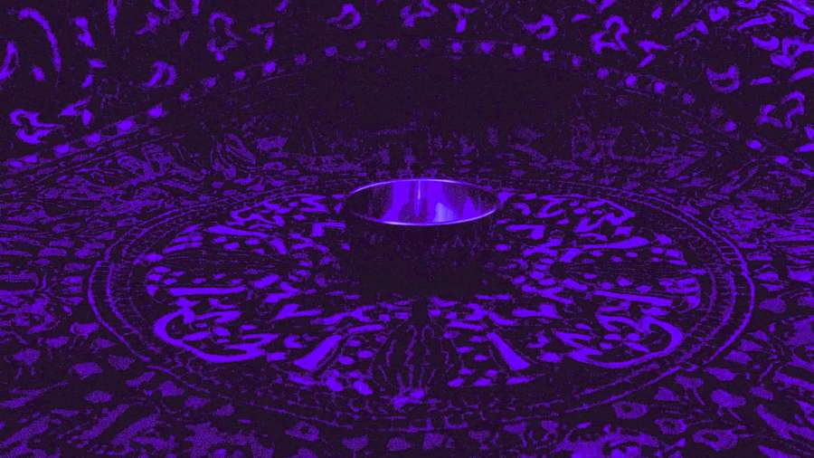 Eine leuchtend violette Tasse auf einer kreisförmig gemusterten Oberfläche unter violettem Licht. — Chakra Hintergrundbild