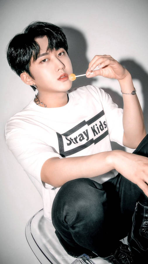 Young man holding lollipop in studio portrait — Changbin Background