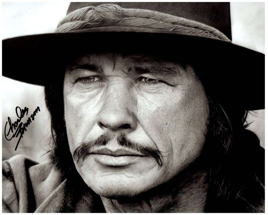 Charles Bronson in a close-up portrait wearing a hat with a signature visible. — Charles bronson Wallpaper