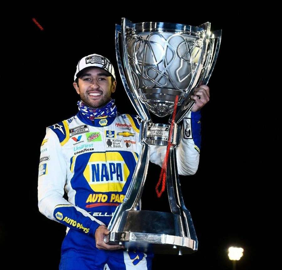 NASCAR driver holding championship trophy at night event — Chase Elliott Picture