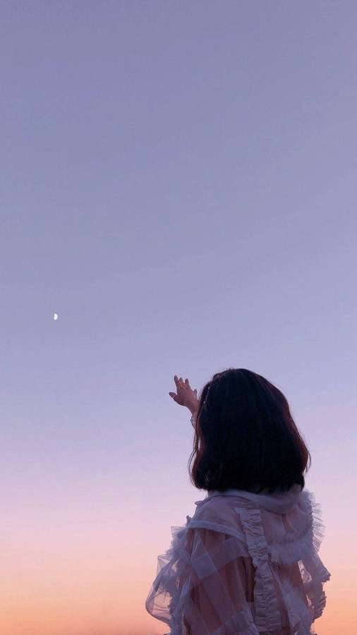 Pessoa de vestido branco alcançando a lua ao entardecer — Chefe Papéis de Parede