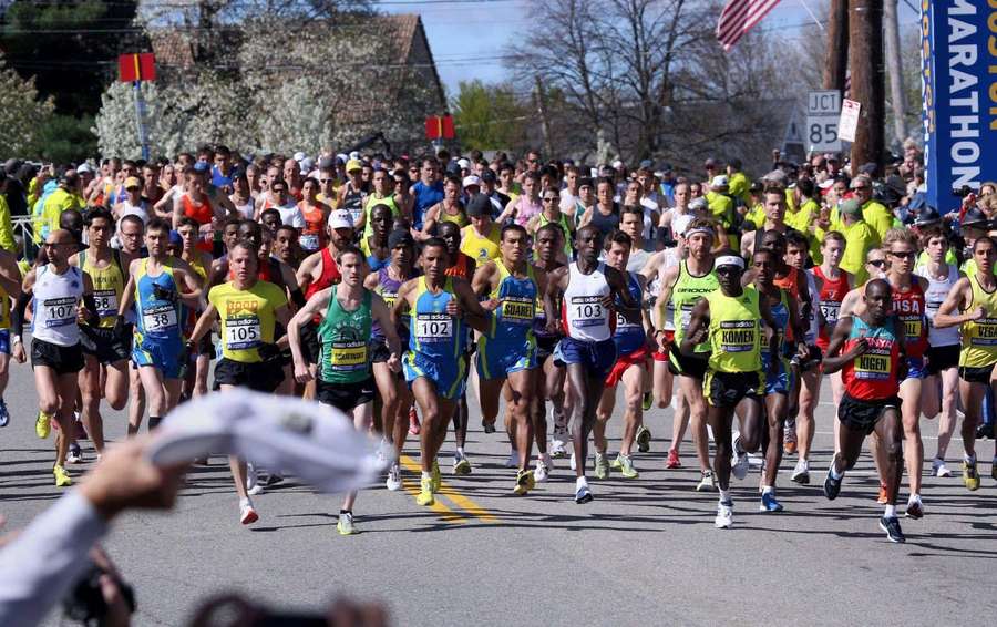 Marathon runners racing down a sunlit street with spectators cheering. — Chicago Marathon Wallpaper