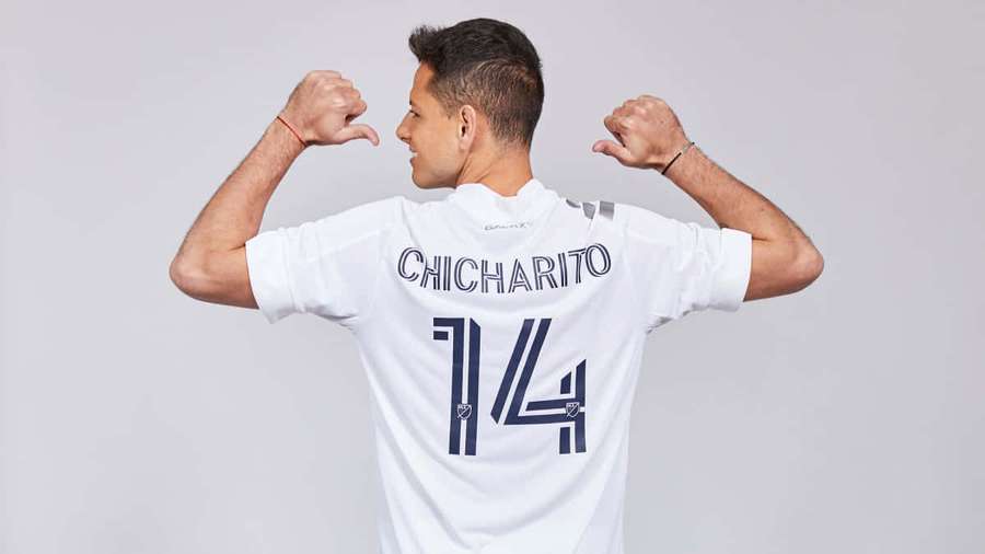 Soccer player Chicharito in white jersey number 14 flexing arms. — Chicharito Wallpaper