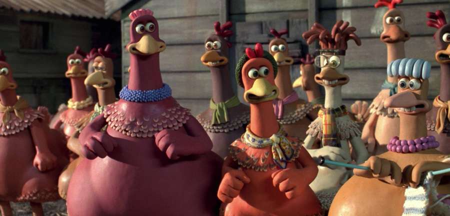 A group of stylized clay chickens wearing colorful outfits in a barn. — Chicken Run Picture