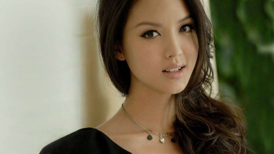 Kvinna med mörkt hår och silverhalsband som tittar mjukt mot kameran. — Chinese Girl Bakgrundsbilder