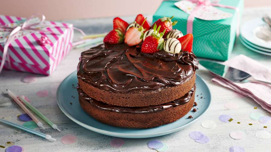 Chocolate cake with strawberries and gifts on a festive table. — Chocolate Cake Background