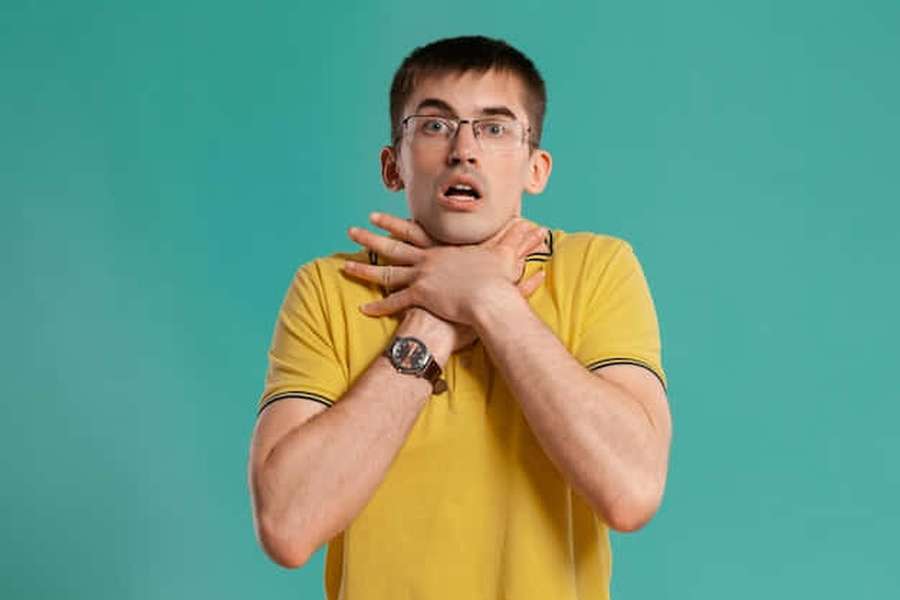Man clutching his throat in panic against teal background — Choking Wallpaper