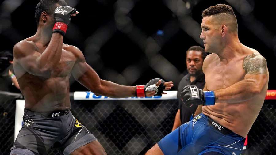 Zwei männliche Kämpfer mit MMA-Handschuhen tauschen Schläge in einem achteckigen Käfig aus. — Chris Weidman Bilder