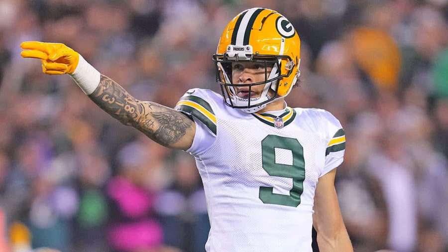 Quarterback Green Bay Packers menunjuk saat pertandingan malam. — Christian Watson Wallpaper