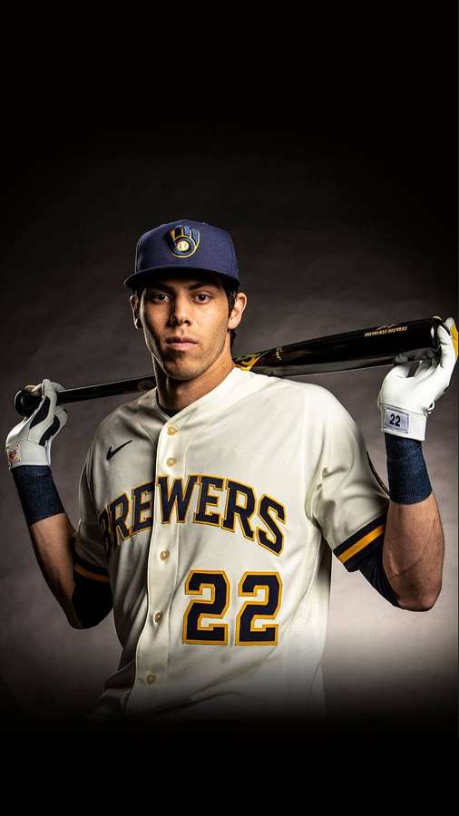 Baseball player in Brewers uniform holding bat in studio — Christian Yelich Wallpaper