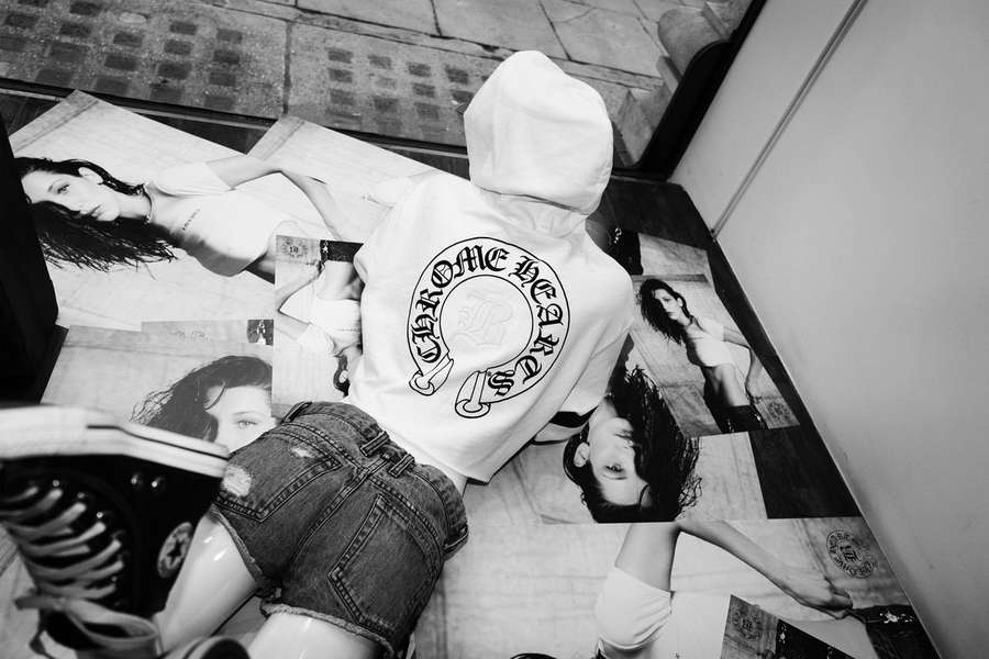Person in hoodie and shorts lying on floor covered with celebrity photos. — Chrome Hearts Background