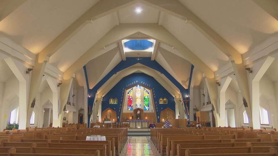 A spacious church with wooden pews and a blue arched altar with stained glass windows. — Church Background