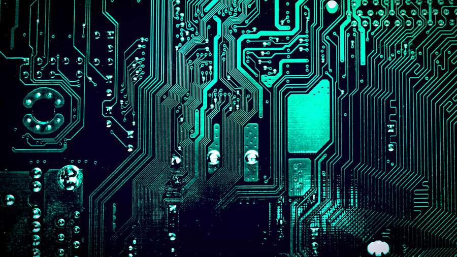 Glowing teal circuit board with intricate pathways and soldered components. — Circuit Board Background