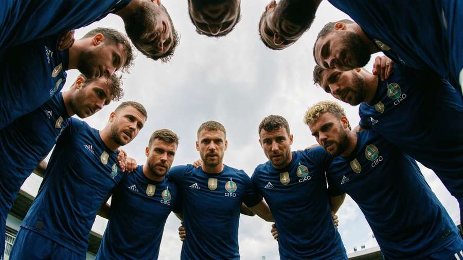 Soccer players in blue jerseys huddle together outdoors under cloudy sky. — Ciro Immobile Picture