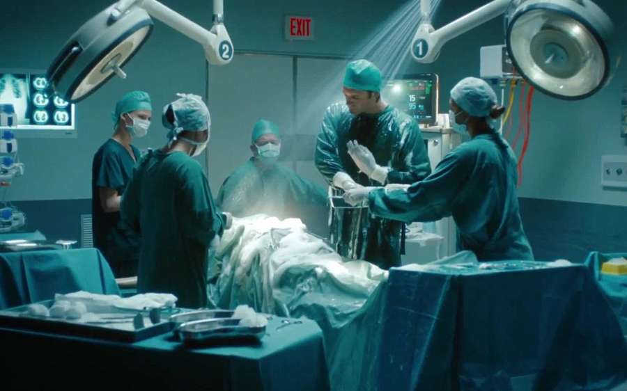 Equipo médico realizando una cirugía en un quirófano brillantemente iluminado. — Cirujano Fondos de pantalla