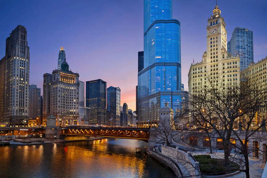 Chicago skyline at dusk with illuminated skyscrapers and a bridge over the river. — City Picture