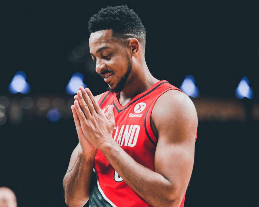 Basketball player in red jersey clasping hands in prayer during game. — Cj Background