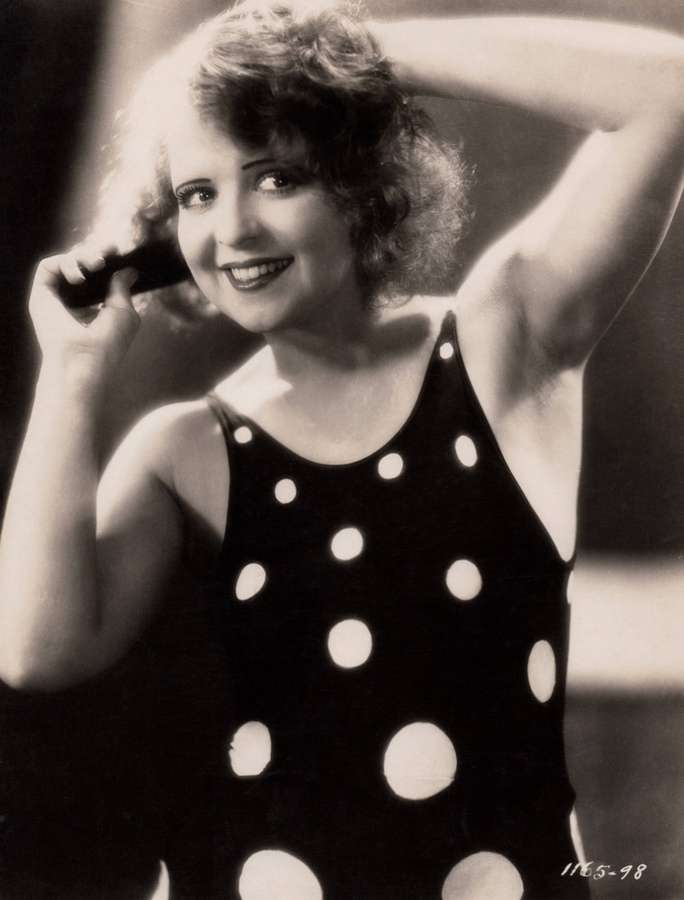 Lächelnde Frau in gepunktetem Badeanzug posiert in einem Vintage-Studiofoto. — Clara Bow Wallpaper