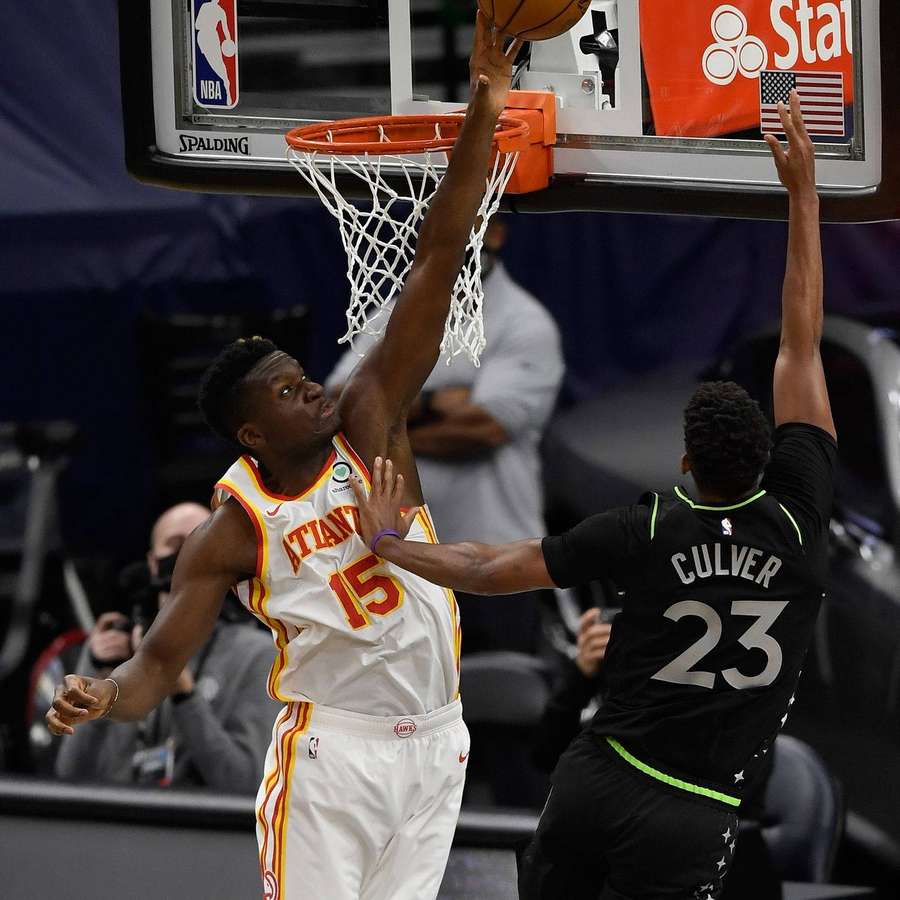 Jugador de Atlanta Hawks clava balón mientras defensor intenta bloquear. — Clint Fondos de pantalla