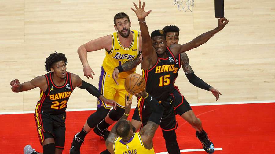 Basketball players in yellow and black jerseys compete for a rebound during a game. — Clint Background