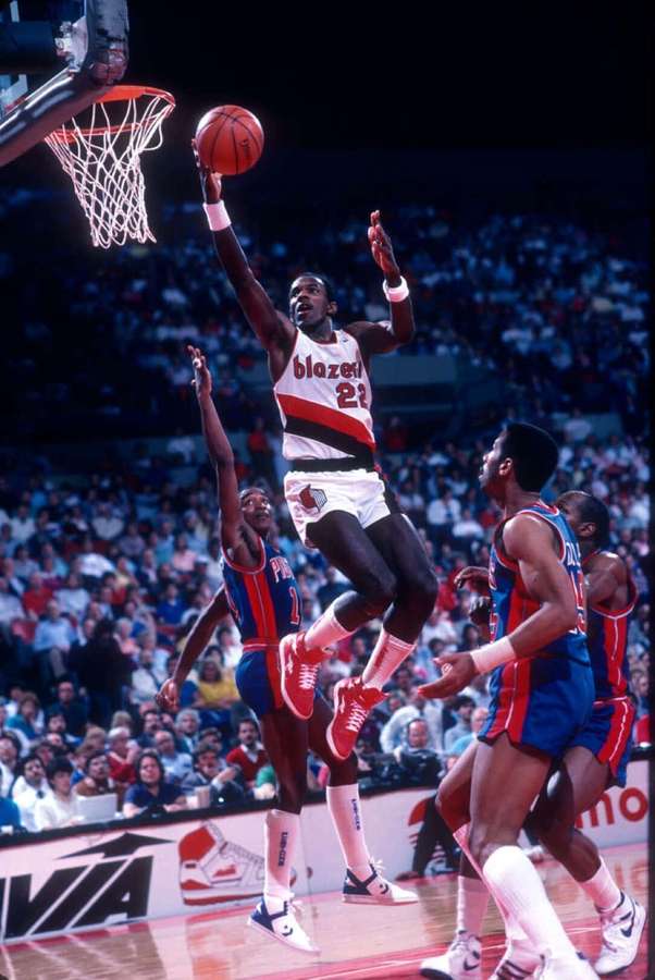 Basketball player dunking over defenders in a packed arena. — Clyde Drexler Wallpaper