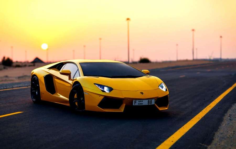 Lamborghini amarillo acelerando en carretera del desierto al atardecer. — Coche amarillo Fondos de pantalla