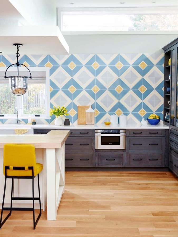 Cocina moderna con azulejos geométricos azules amarillos, armarios oscuros y taburete de bar amarillo. — Cocina moderna Fondos de pantalla