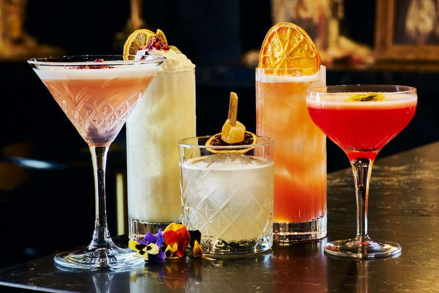 Viisi värikästä cocktailia koristeineen tummalla baaritiski. — Cocktail Taustakuvat