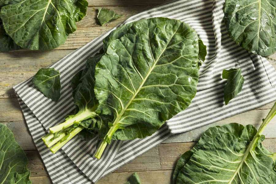 Fresh kale leaves on striped cloth on wooden table — Collard Greens Wallpaper
