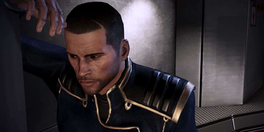 Un hombre serio con un uniforme oscuro con ribetes dorados está de pie en un pasillo metálico. — Comandante Shepard Fondos de pantalla