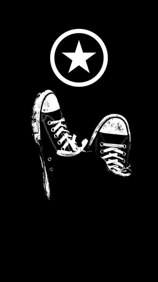 Paar abgenutzter Sneaker unter einem Sternemblem in kontrastreichem schwarz-weißem Grafikstil. — Converse Bilder